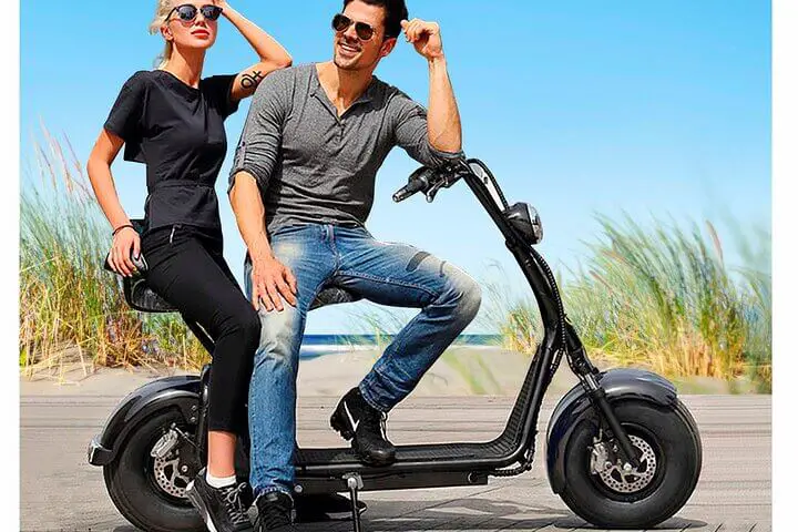 Two adults on an electric scooter